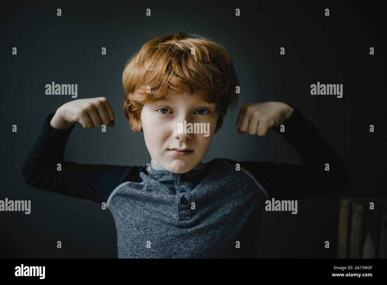 Portrait von rothaarigen Jungen flexing Muskeln Stockfoto