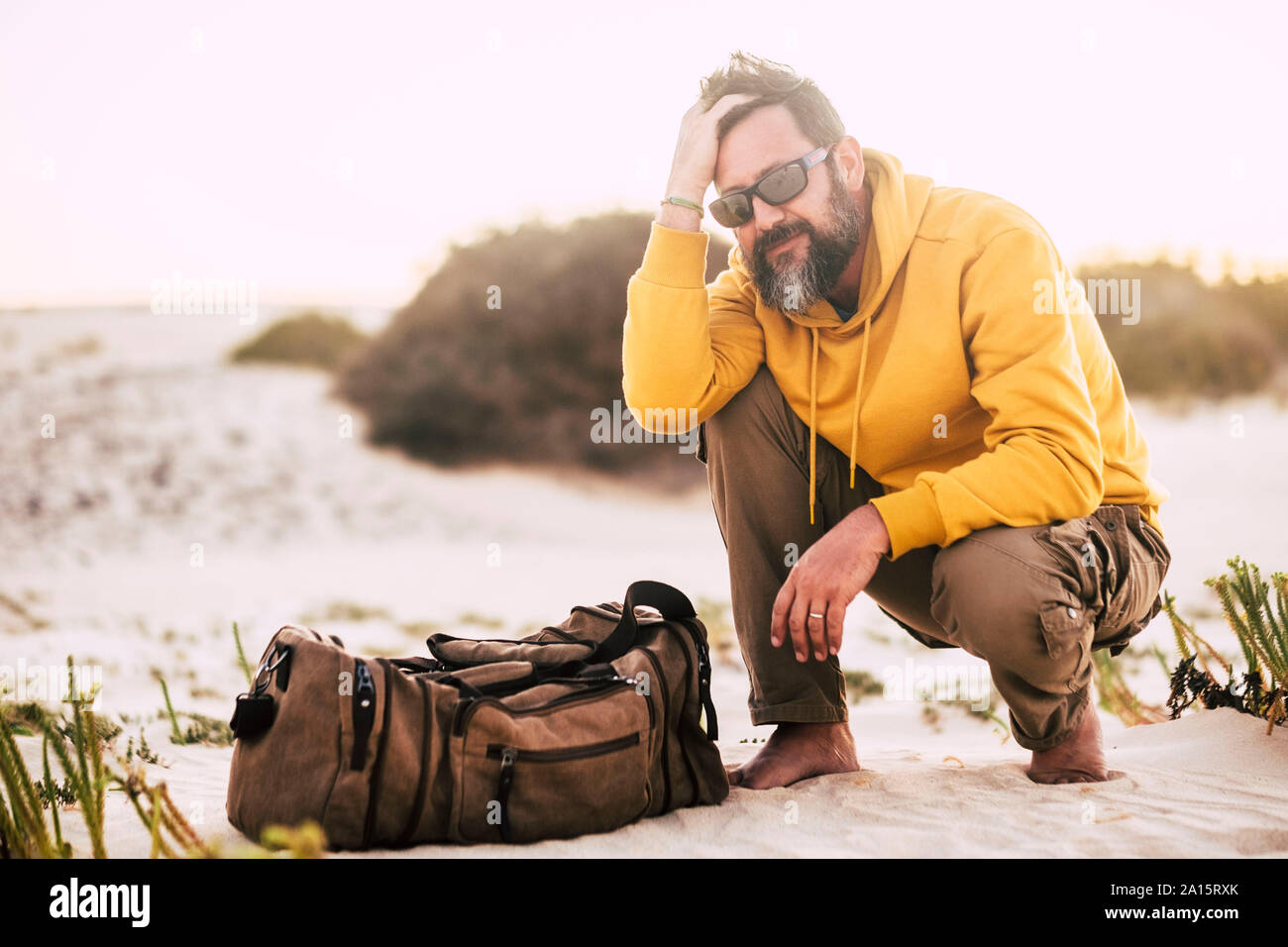 Mann mit gelben und braunen hoodie Pullover Korb am Strand Stockfoto