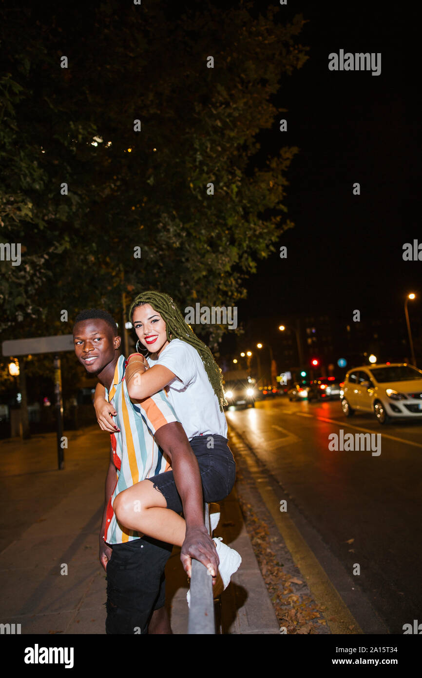 Glückliches junges Paar auf der Straße in der Nacht in der Stadt Stockfoto