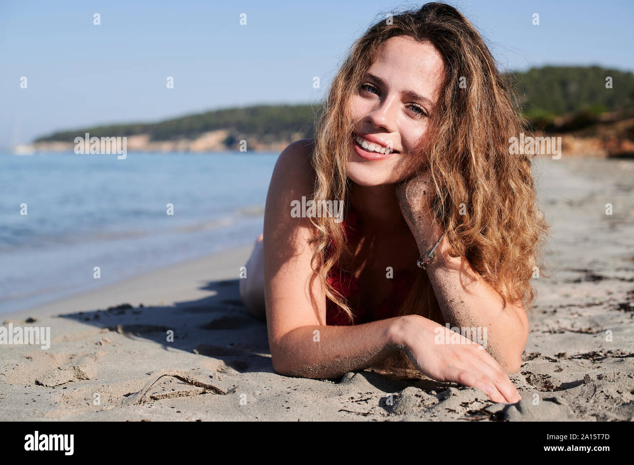 Porträt der glückliche junge Frau am Strand liegen Stockfoto