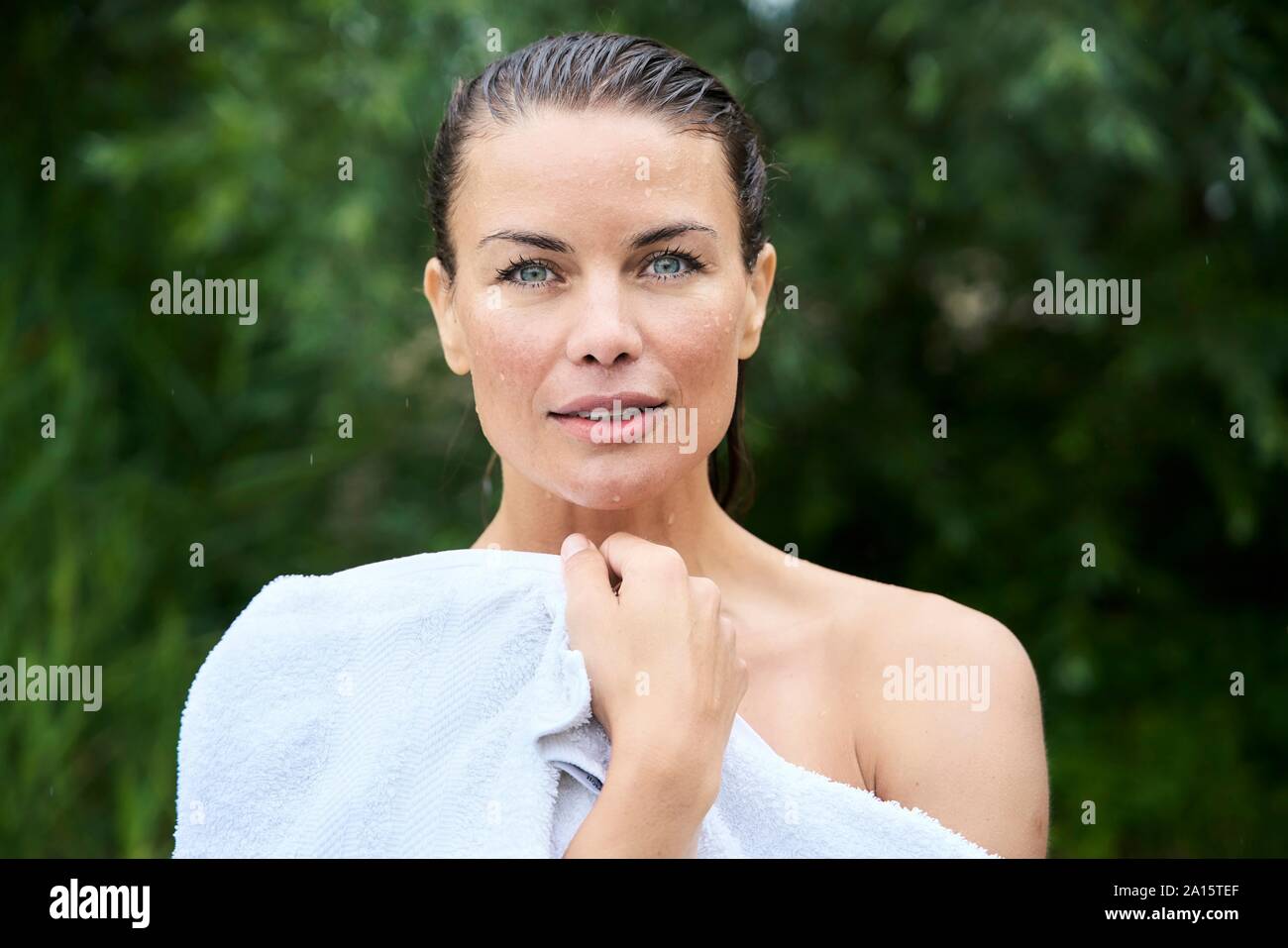 Portrait von Frau mit nassem Haar in ein Handtuch gewickelt in der Natur Stockfoto