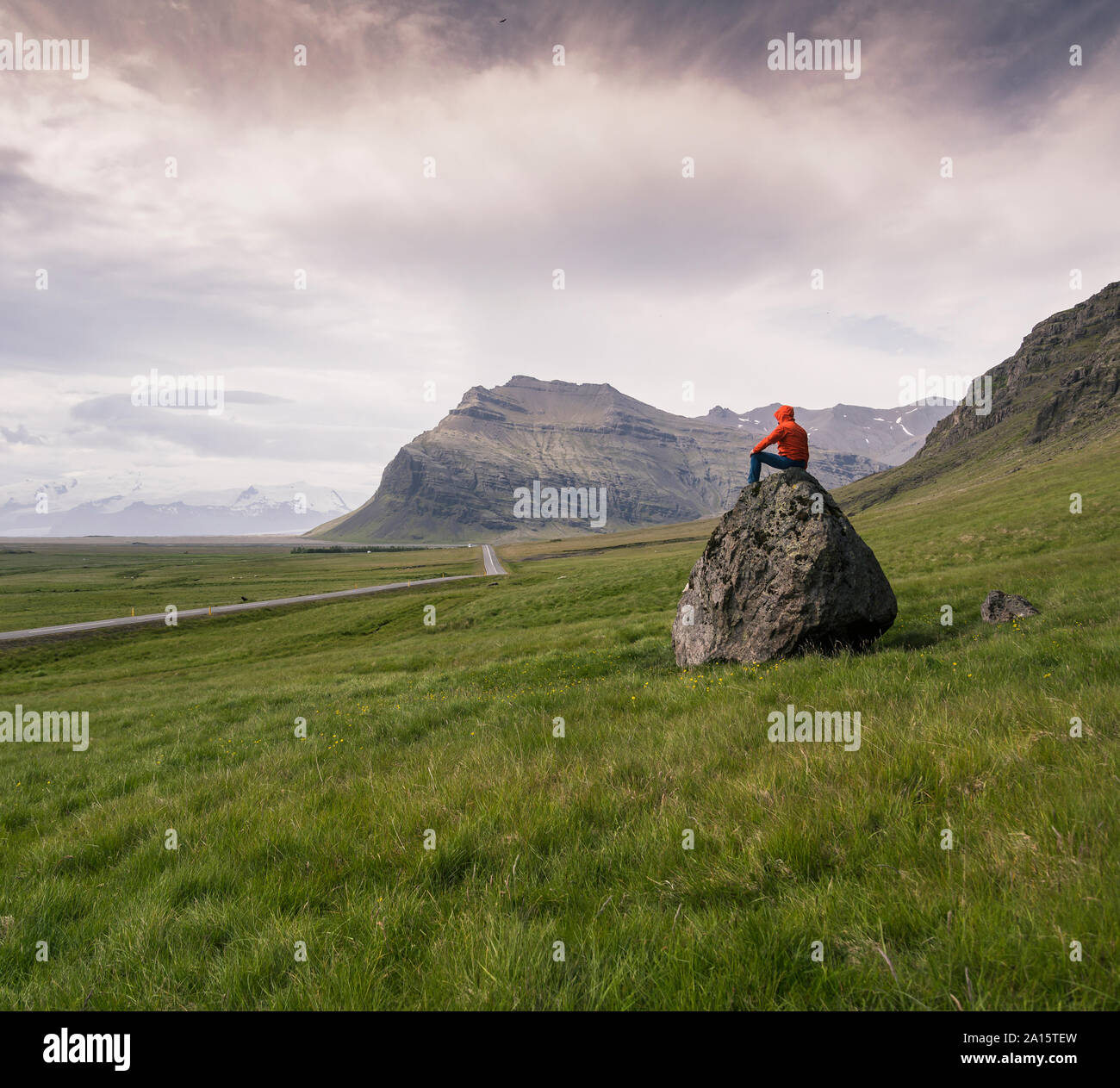 Mann auf Felsen in der Erschliessung der Region Süd, Island sitzen Stockfoto
