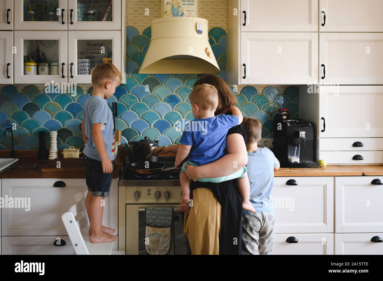 Mutter kochen mit ihren drei Söhnen in der Küche Stockfoto