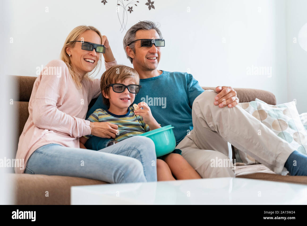 Vater, Mutter und Sohn tragen 3D-Brille auf der Couch zu Hause Fernsehen Stockfoto