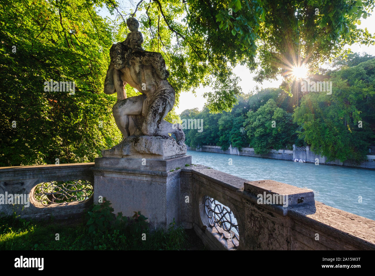 Deutschland, Oberbayern, München, St. Christopher's Statue mit Bäumen von Isar bei Sonnenuntergang umgeben Stockfoto