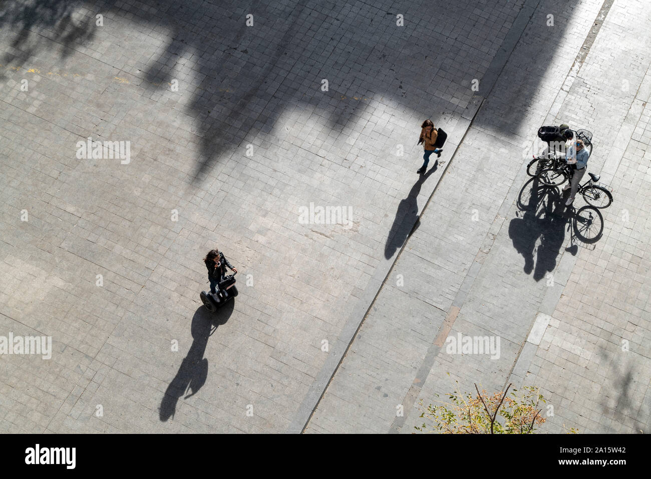 Blick von oben auf die Menschen mit Fahrrädern und Segway Stockfoto