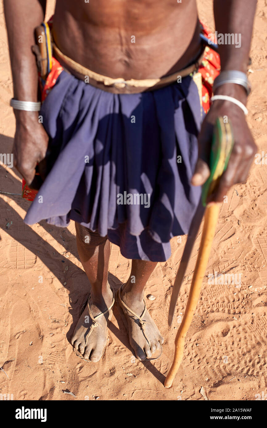 Traditionelle Mudimba Stamm Mann mit einem Stock und einem Messer, Canhimei, Angola. Stockfoto