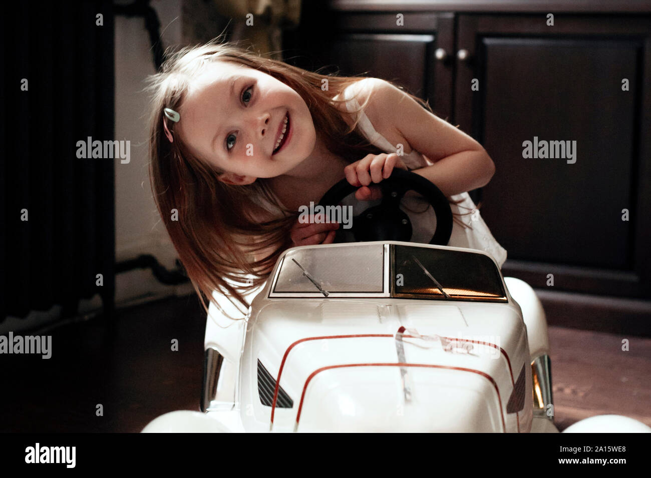 Süße kleine Mädchen fahren ihr Spielzeug Auto Stockfoto