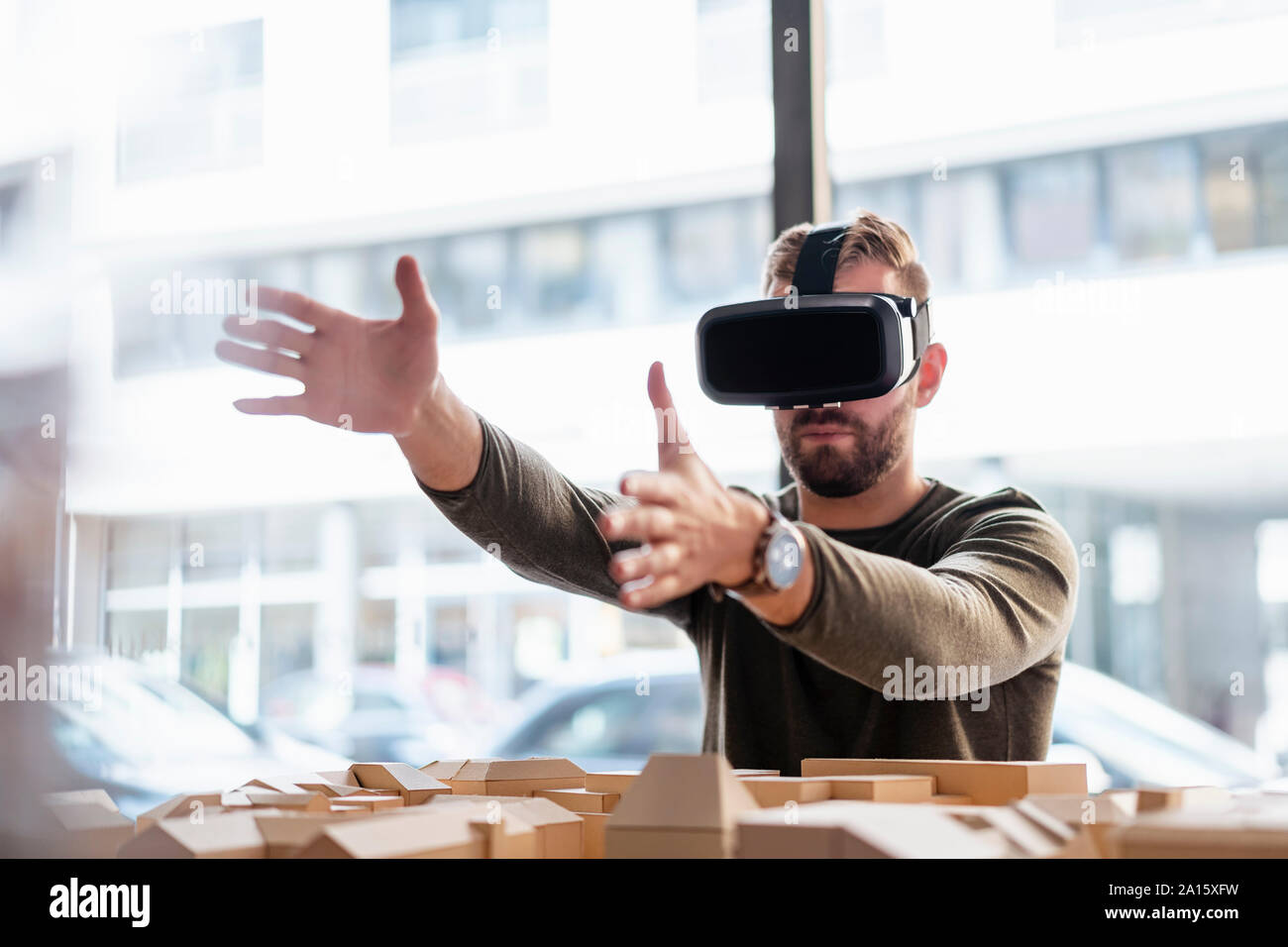Mann mit architektonischen Modell im Büro tragen VR-Brille Stockfoto