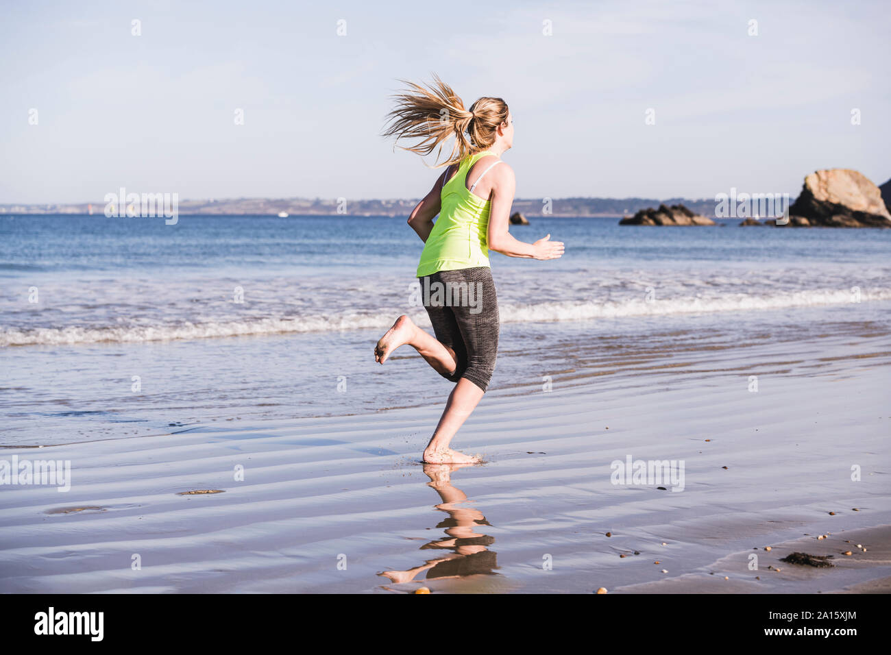 Weibliche Jogger am Strand Stockfoto