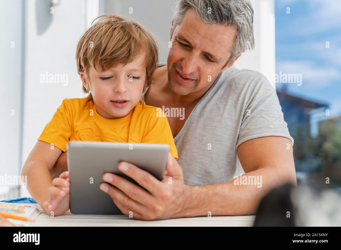 Vater und Sohn mit Tablet zusammen auf der Terrasse Stockfoto
