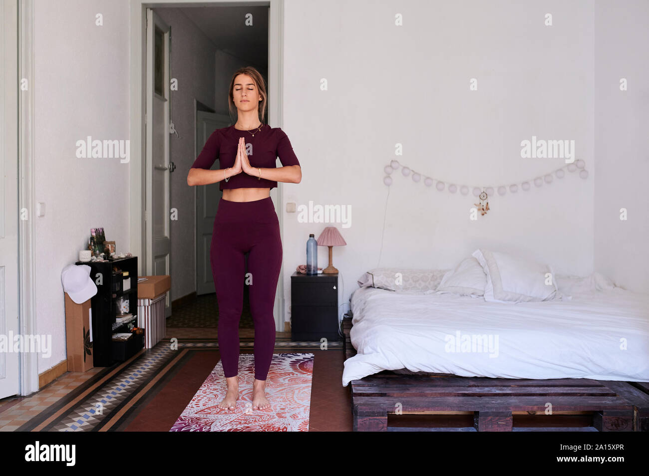 Junge brünette Frau Yoga in Studentenwohnheim Stockfoto