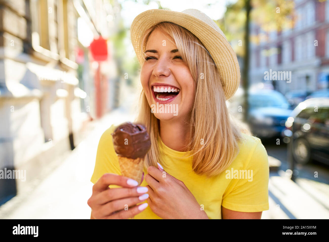 Unbeschwerte junge Frau genießen Sie ein Eis in der Stadt Stockfoto