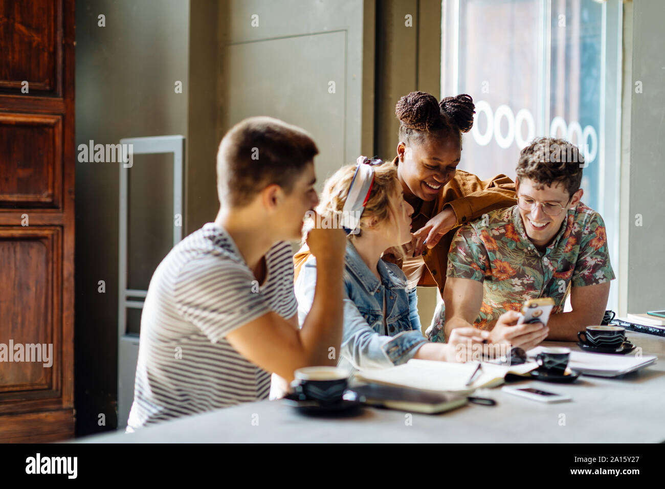 Studenten treffen im Cafe, gemeinsam Lernen mit Laptops und Smartphones Stockfoto