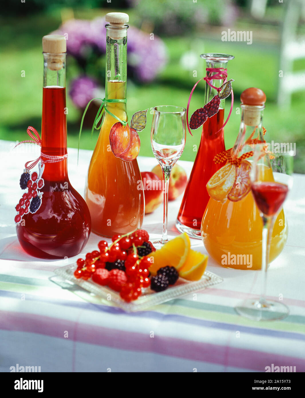 Hausgemachte Fruchtliköre in Karaffen auf Garten Tisch Stockfoto