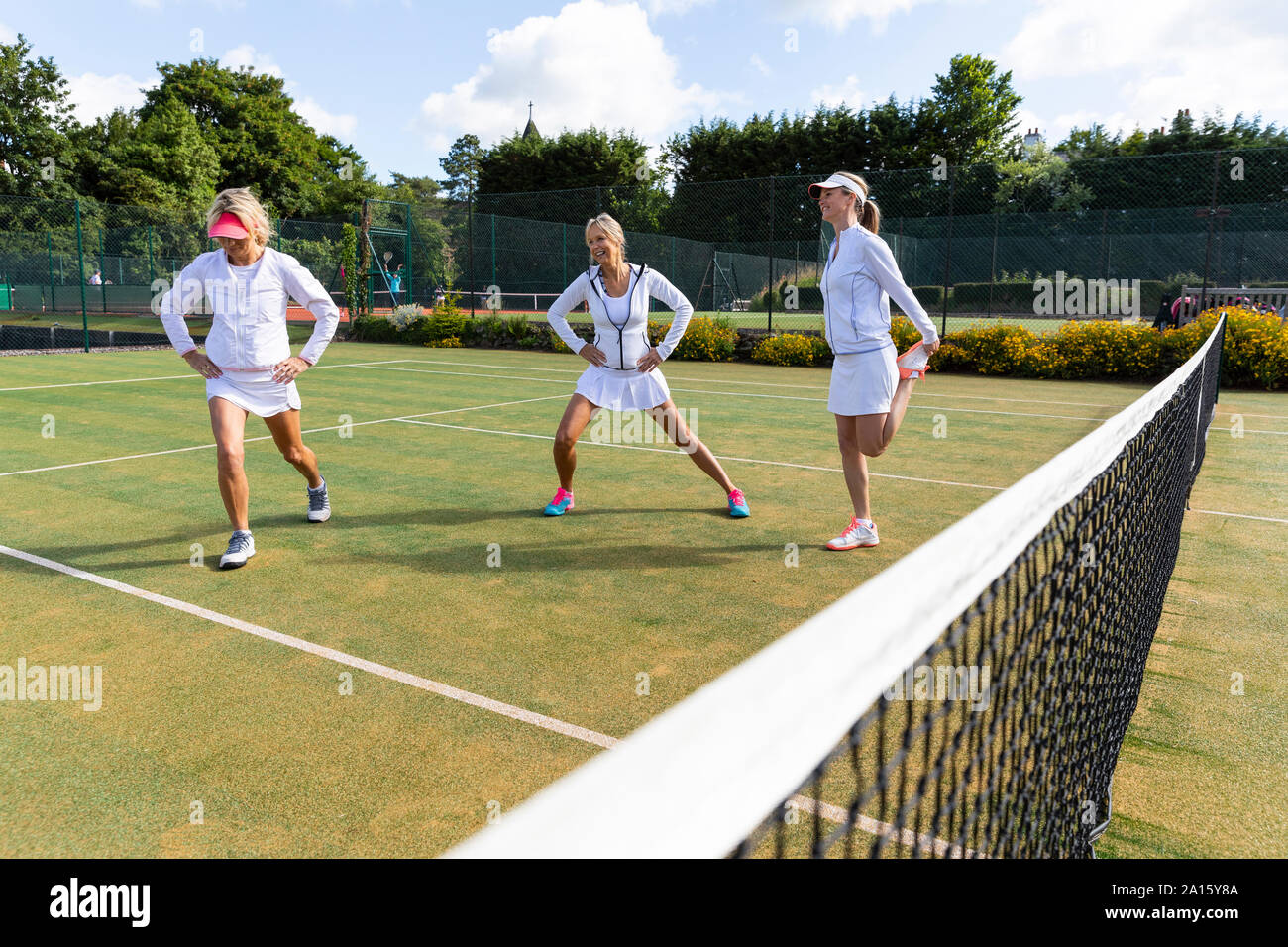 Reife Frauen tun Dehnübungen vor Tennis spielen. Stockfoto