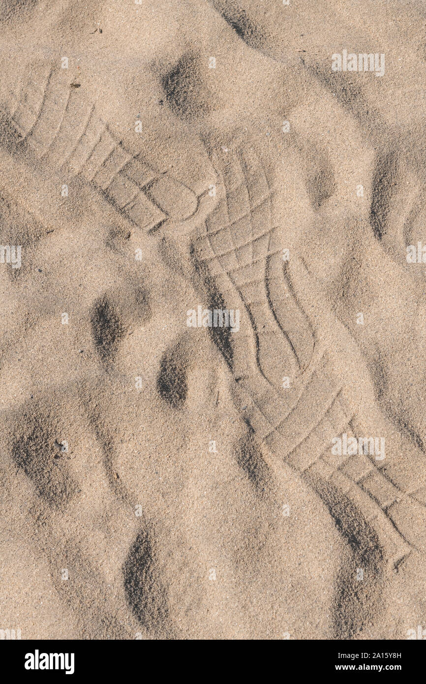 Eher abstrakte Fußspuren im Sand in der Sonne. Sonnigen Tag am Strand Konzept. Stockfoto
