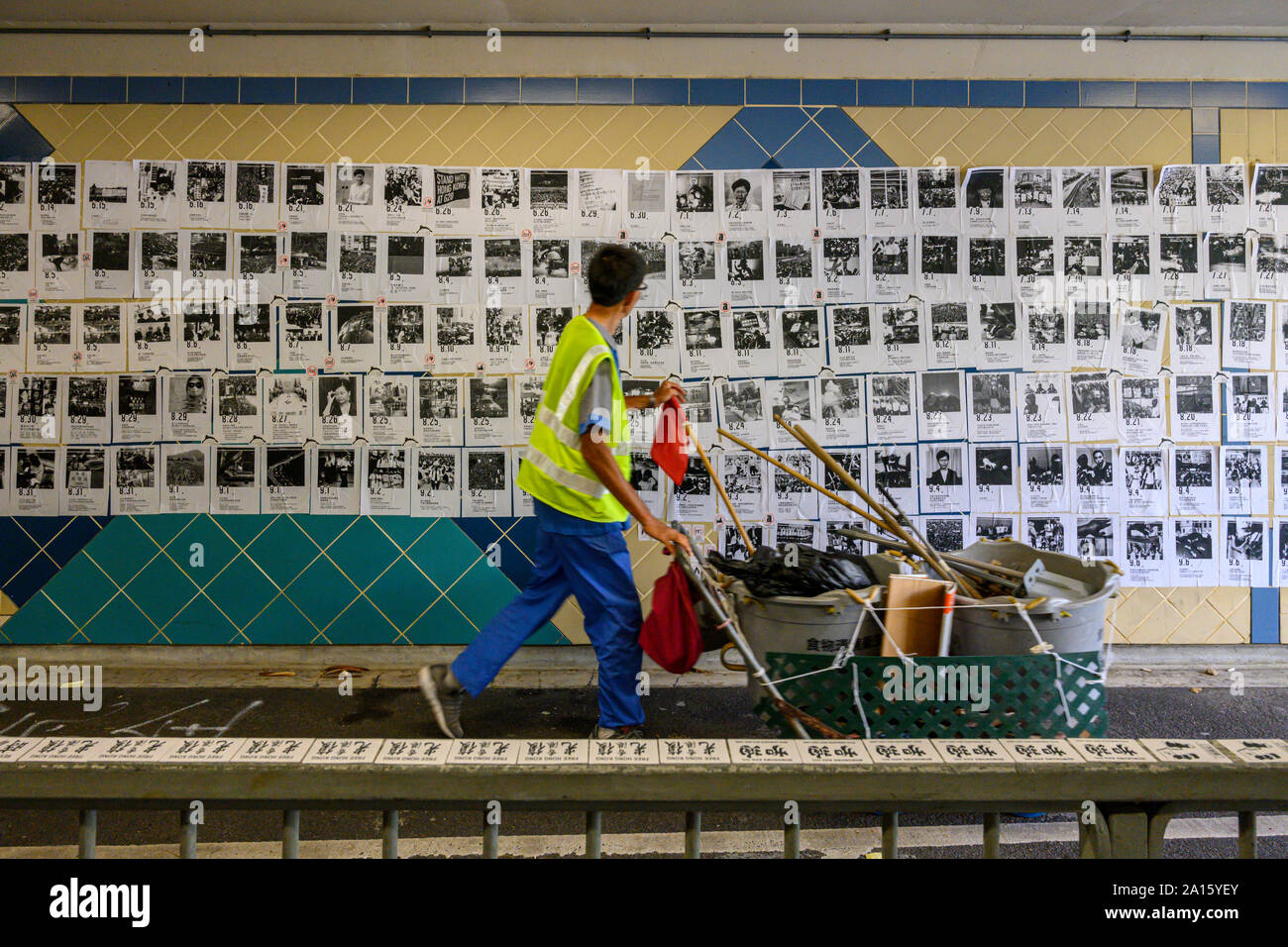 Hung Hau, Hong Kong. 24. September 2019. Eine Straßenkehrmaschine Spaziergänge durch eine Lennon Wand hing Hau. Dies ist eine von vielen Lennon Wände mit Postern, Nachrichten und Grafitti, um Hongkong zu finden sind. Stockfoto