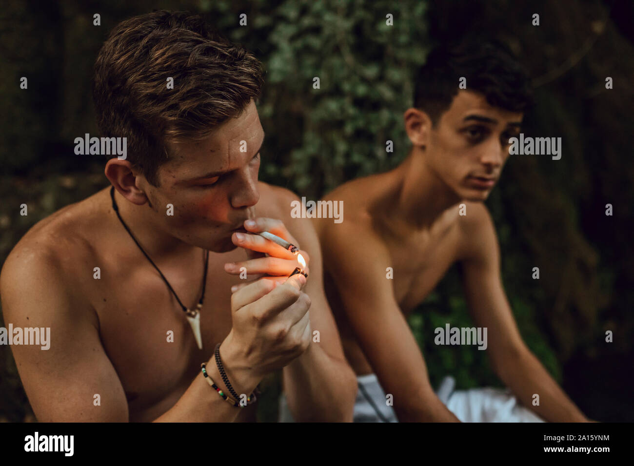 Zwei barechested Freunde rauchen einen Joint Marihuana in der Natur Stockfoto