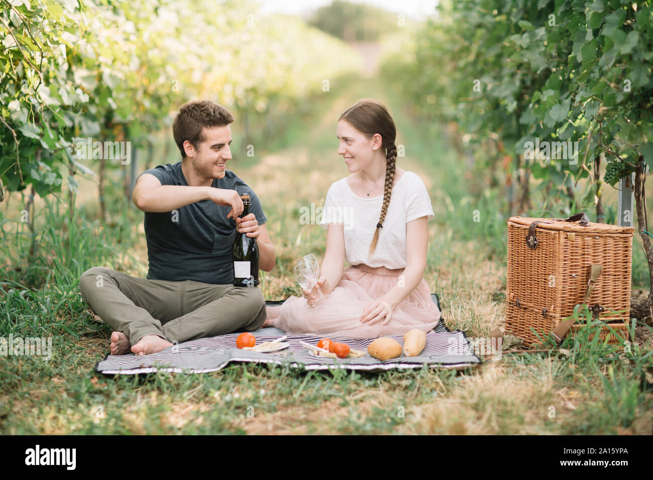 Glückliches junges Paar mit Picknick in den Weinbergen Stockfoto