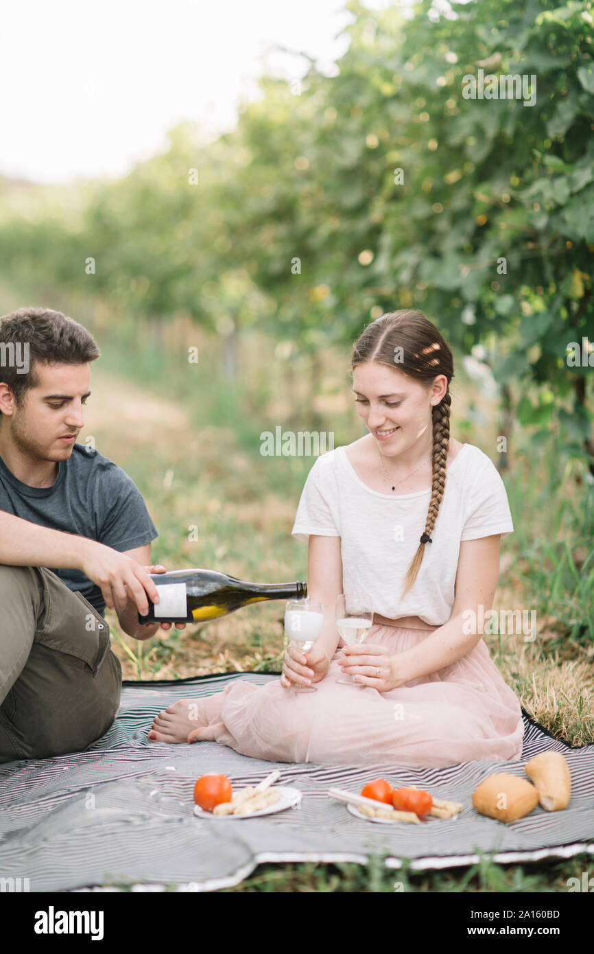 Glückliches junges Paar in Picknick mit Prosecco in den Weinbergen Stockfoto
