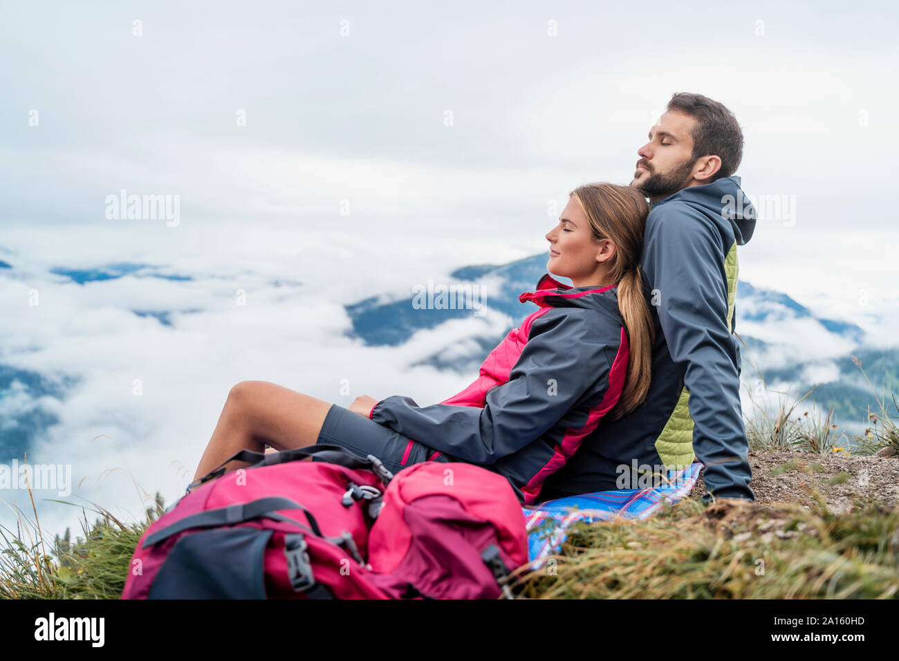 Liebevolle junge Paare auf einer Wanderung in den Bergen eine Pause, Herzogstand, Bayern, Deutschland Stockfoto
