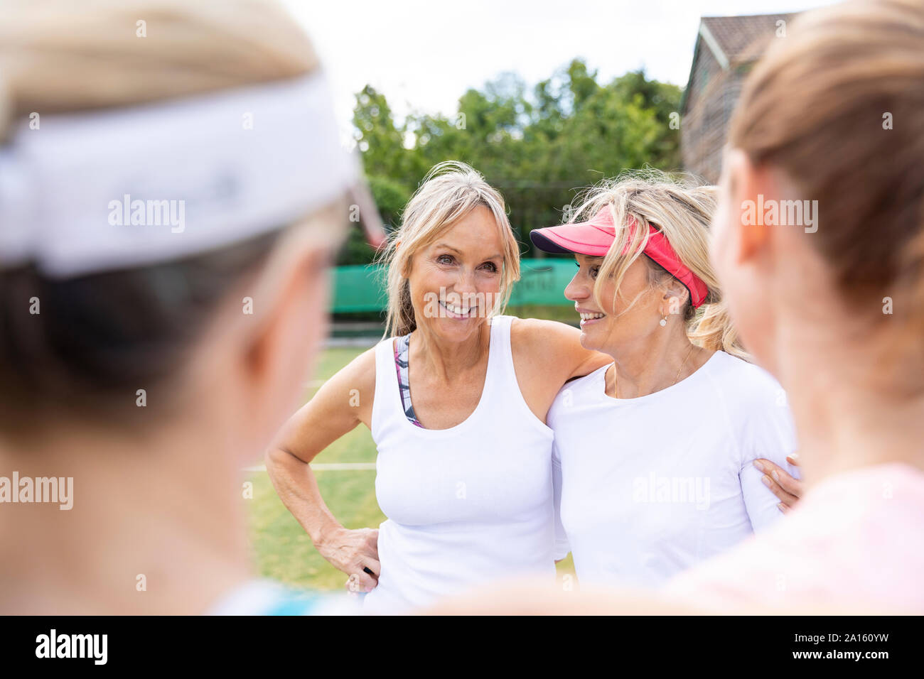 Reife Frauen sprechen auf Gras Court Tennis Club Stockfoto
