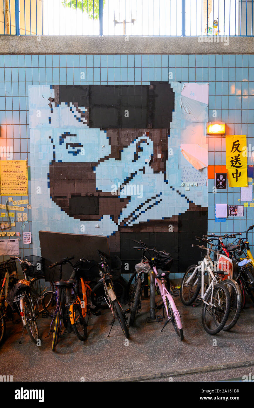 Tai Po, Hong Kong. 23. September 2019. Ein Wandbild eines maskierten pro Demokratie Demonstrant. Dies ist eine von vielen Lennon Wände mit Postern, Nachrichten und Grafitti, um Hongkong zu finden sind. Stockfoto