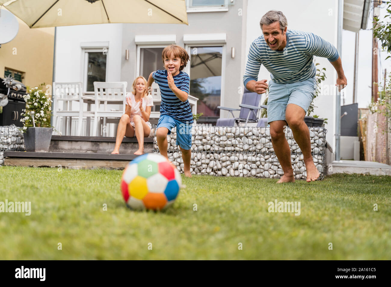 Vater und Sohn im Garten Fußball spielen Stockfoto