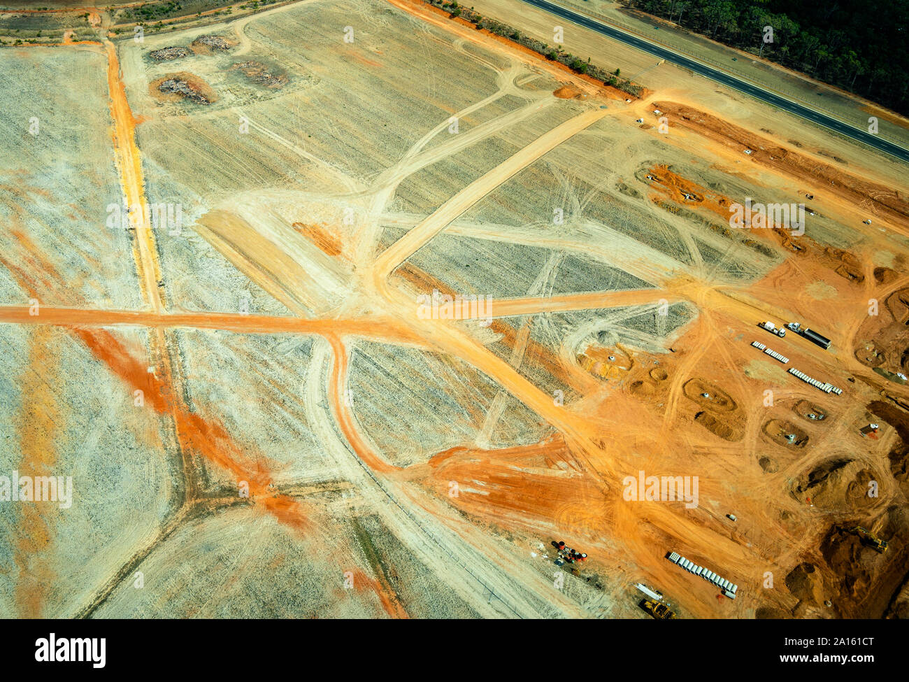 Luftaufnahme eines Steinbruchs mit Lkw Bewegung, orange Sand in Queensland, Australien Stockfoto
