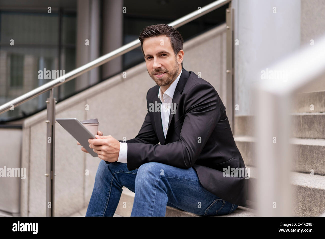 Geschäftsmann mit Tablet sitzen auf der Treppe in der Stadt Stockfoto