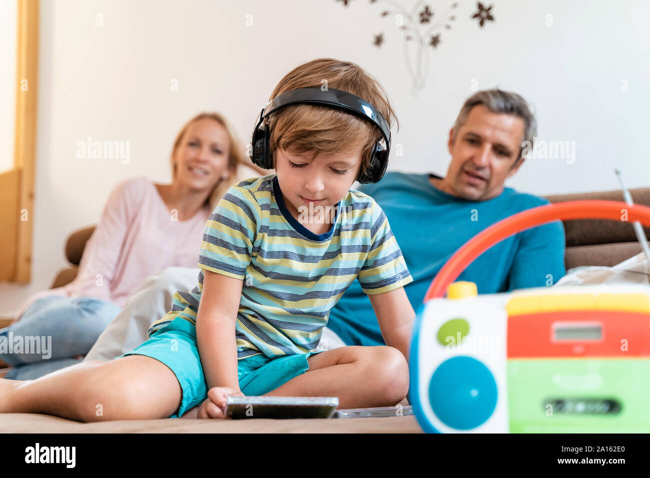 Familie auf der Couch zu Hause mit junge Musik hören mit Kopfhörern Stockfoto