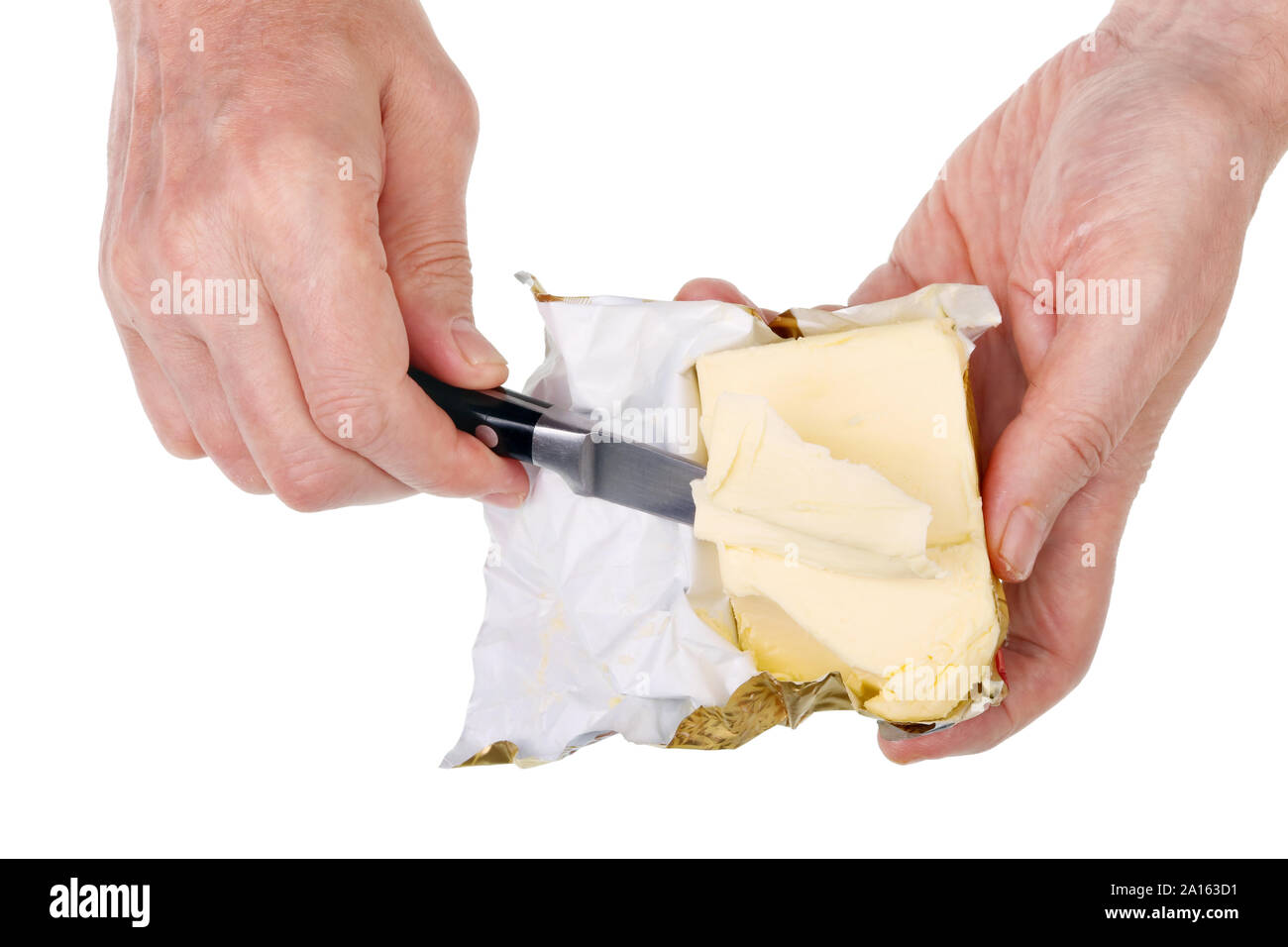 Alten armen älteren Mann schneidet einen Stick von gelben Butter mit einem scharfen Messer. Auf weissem Studio closeup isoliert. Stockfoto