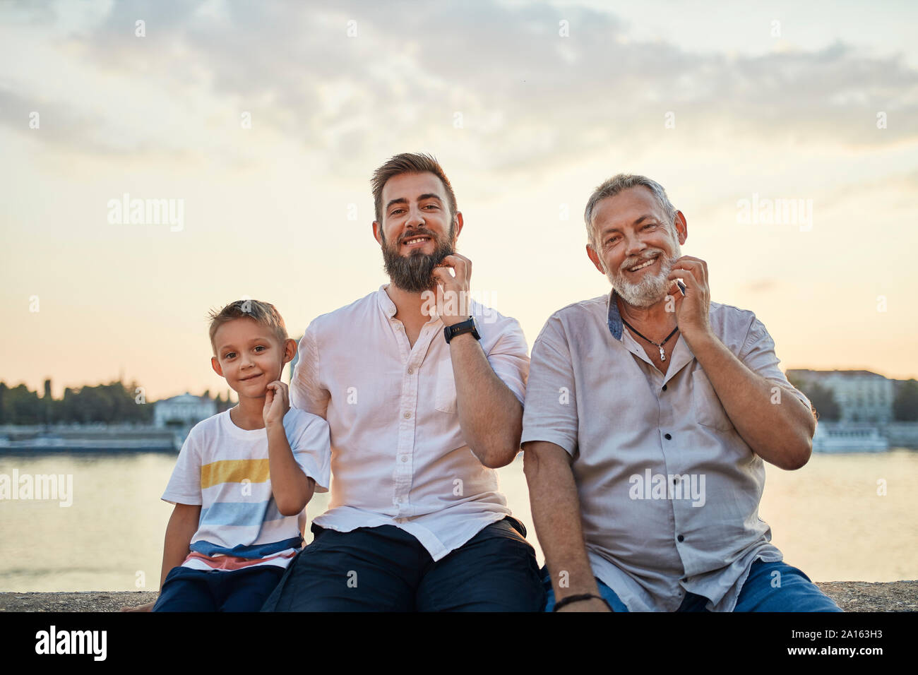Portrait von lächelnden Vater und erwachsener Sohn mit gandson Kratzen ihre Bärte Stockfoto