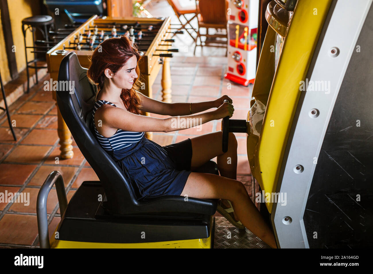 Junge Frau mit Fahrsimulator in einer Sports Bar Stockfoto
