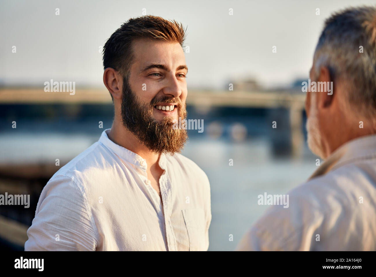 Happy erwachsener Sohn Gespräch mit Vater im Freien Stockfoto