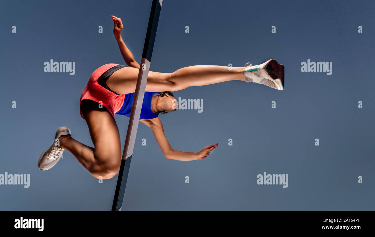 Der Froschperspektive weiblicher Runner Kreuzung Hürde Stockfoto