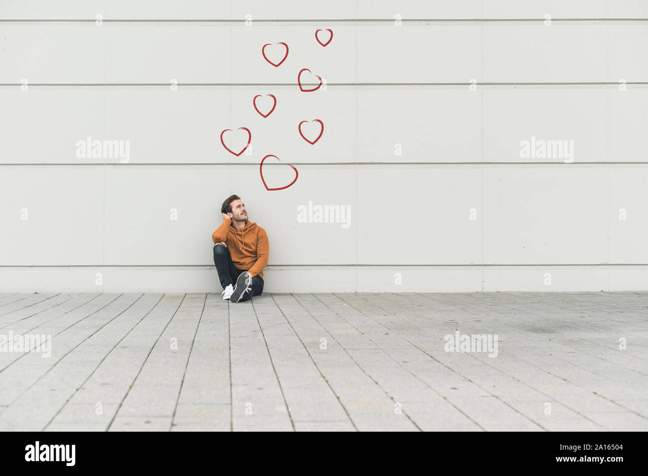 Digital composite junger Mann, der an einer Wand Stockfoto