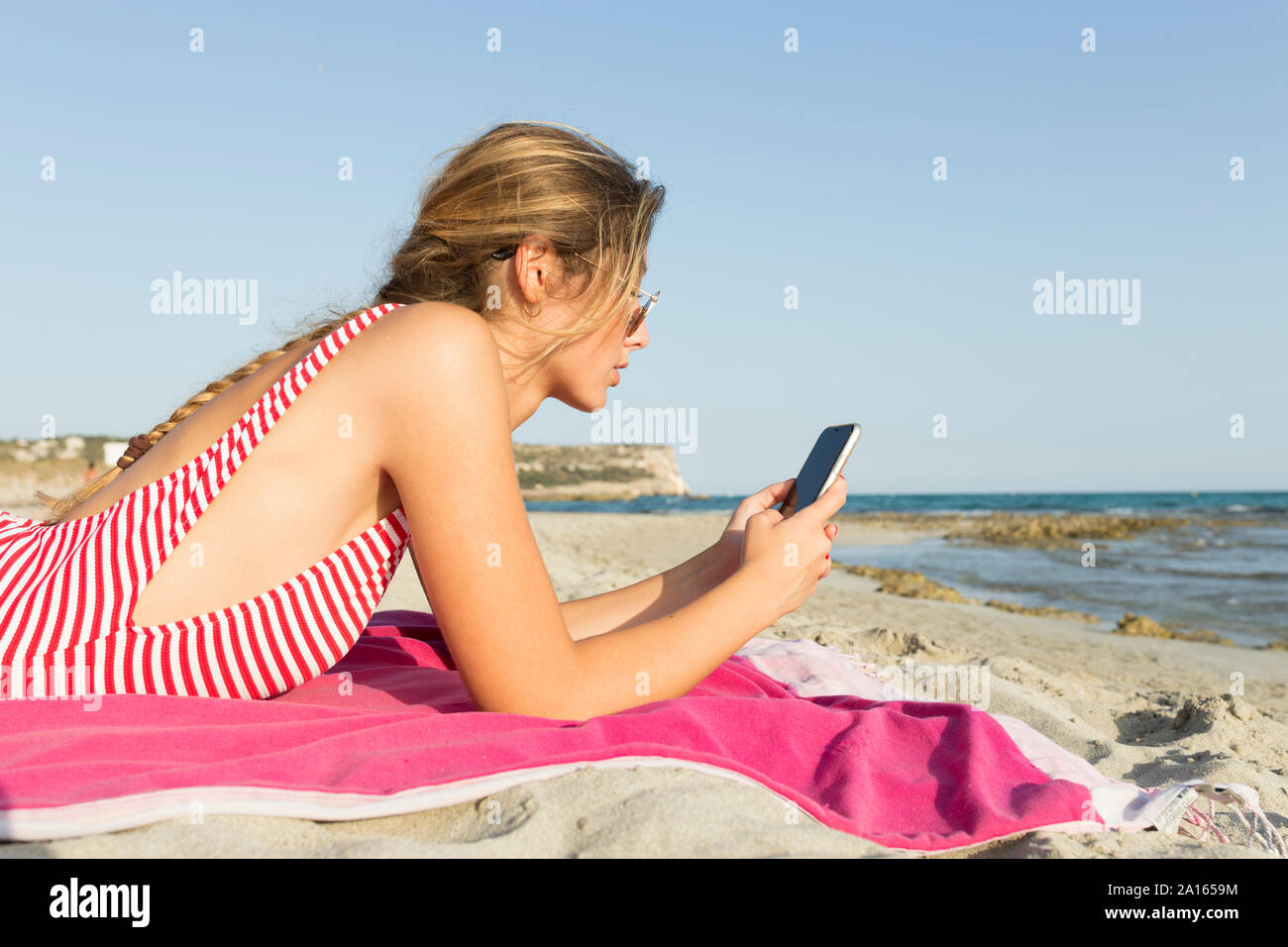 Junge Frau Sie ihr Smartphone am Strand Stockfoto