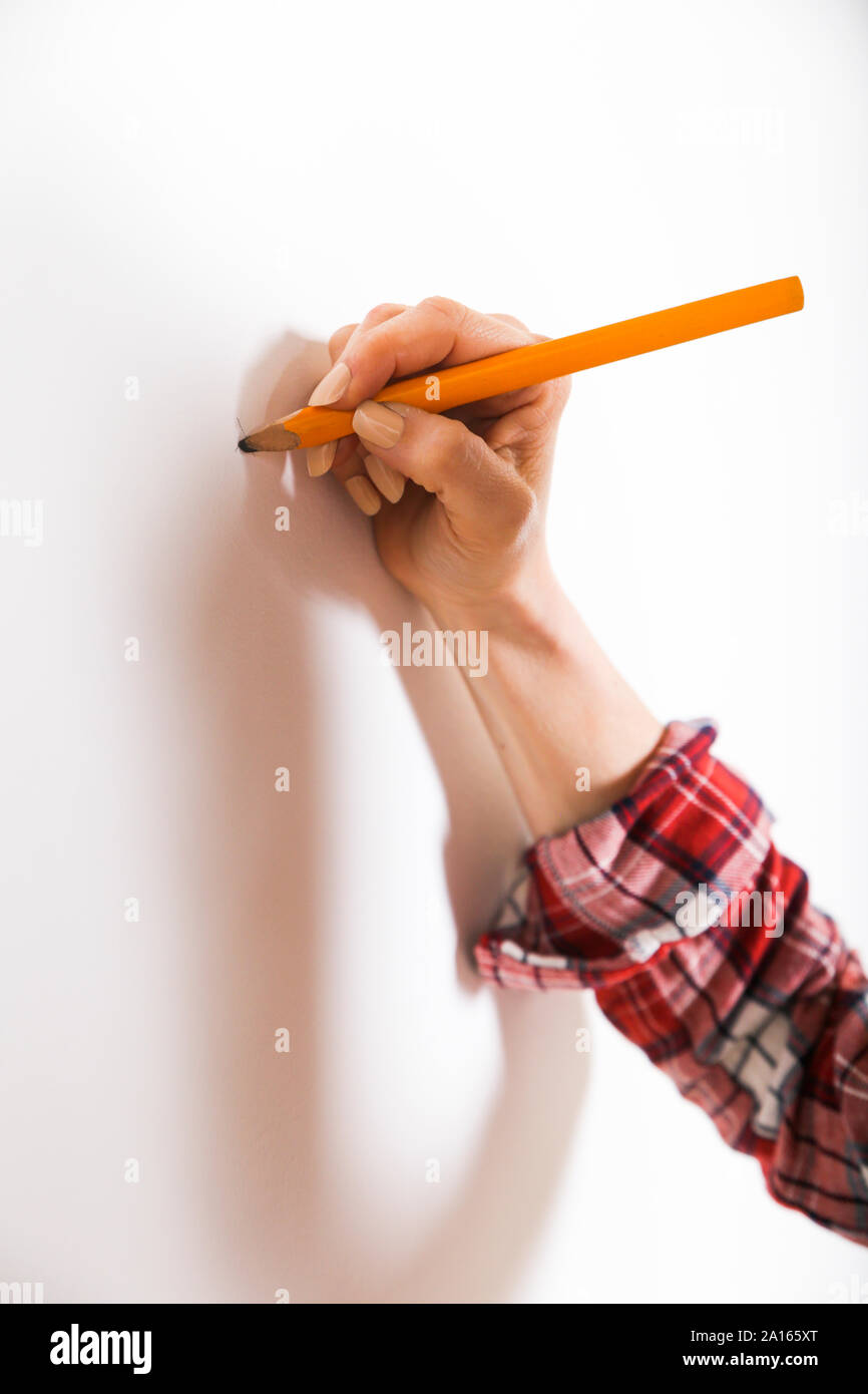 Frau Kennzeichnung mit Bleistift an der Wand Stockfoto