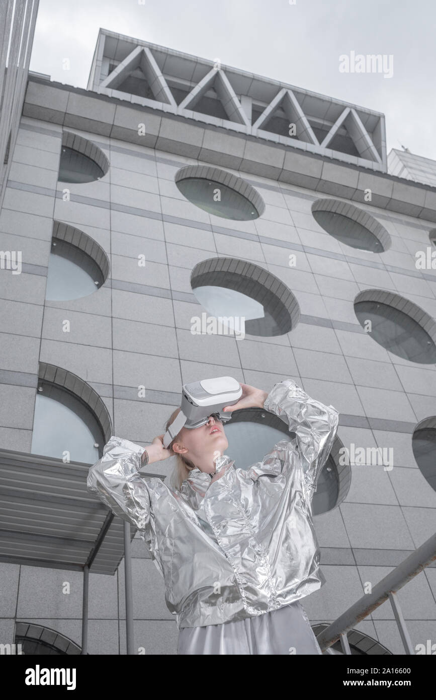 Mädchen in Silber. Durch VR-Brille in futuristischen Stadt Stockfoto