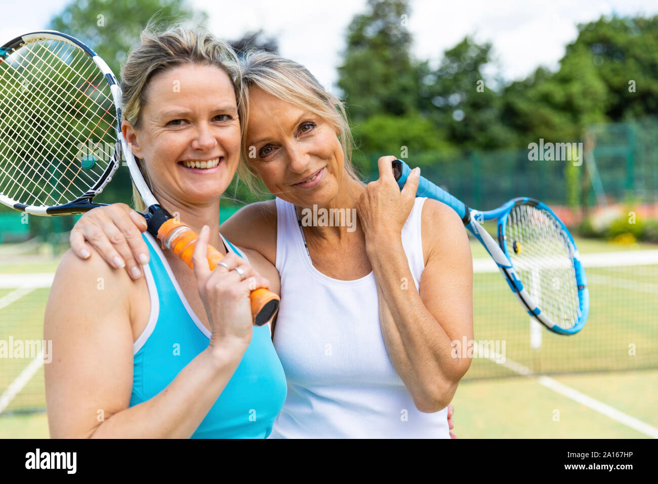 Porträt von zwei Glückliche reife Frauen auf Gras Court Tennis Club Stockfoto