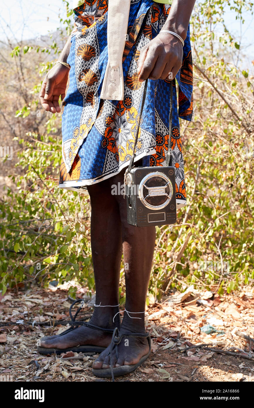 Ndengelengo Mann, Radio auf seinen Händen, Garganta, Angola. Stockfoto