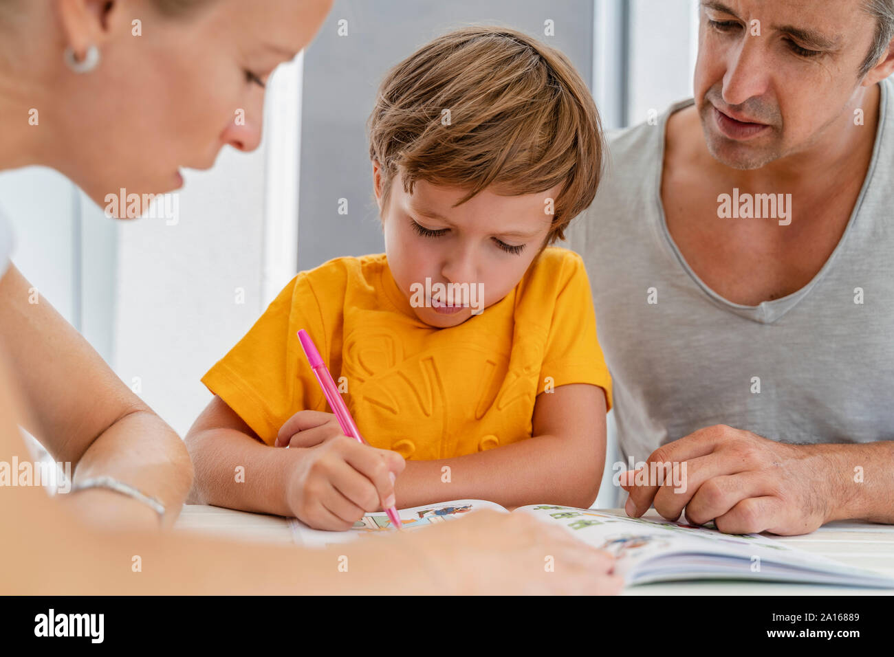 Vater, Mutter und Sohn Hausaufgaben zusammen auf der Terrasse Stockfoto