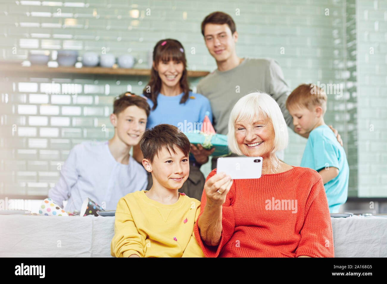 Mutter und Kinder feiern Großmutter bithday in ihrer Küche, junge selfies unter Stockfoto