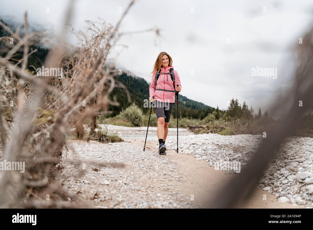 Junge Frau auf einer Wanderung am Flußufer, Vorderriss, Bayern, Deutschland Stockfoto