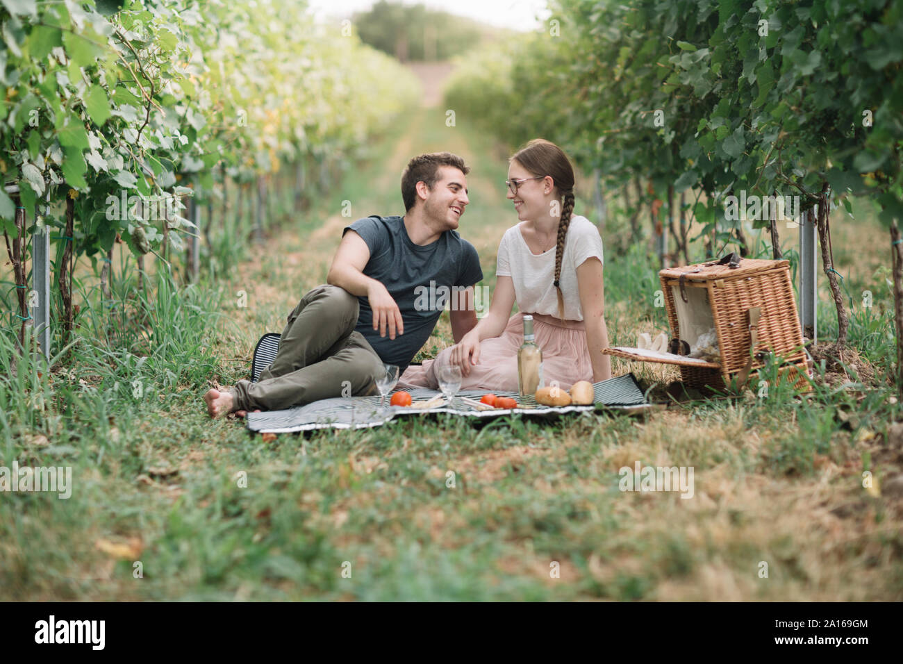 Glückliches junges Paar mit Picknick in den Weinbergen Stockfoto