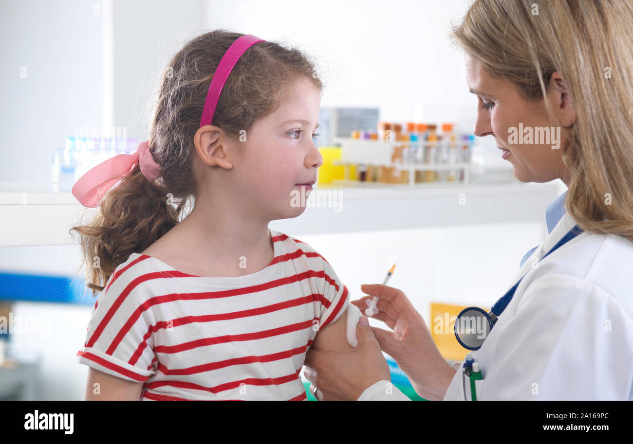 Weibliche Arzt, ein junges Mädchen, eine routinemässige Impfung in der Klinik Stockfoto