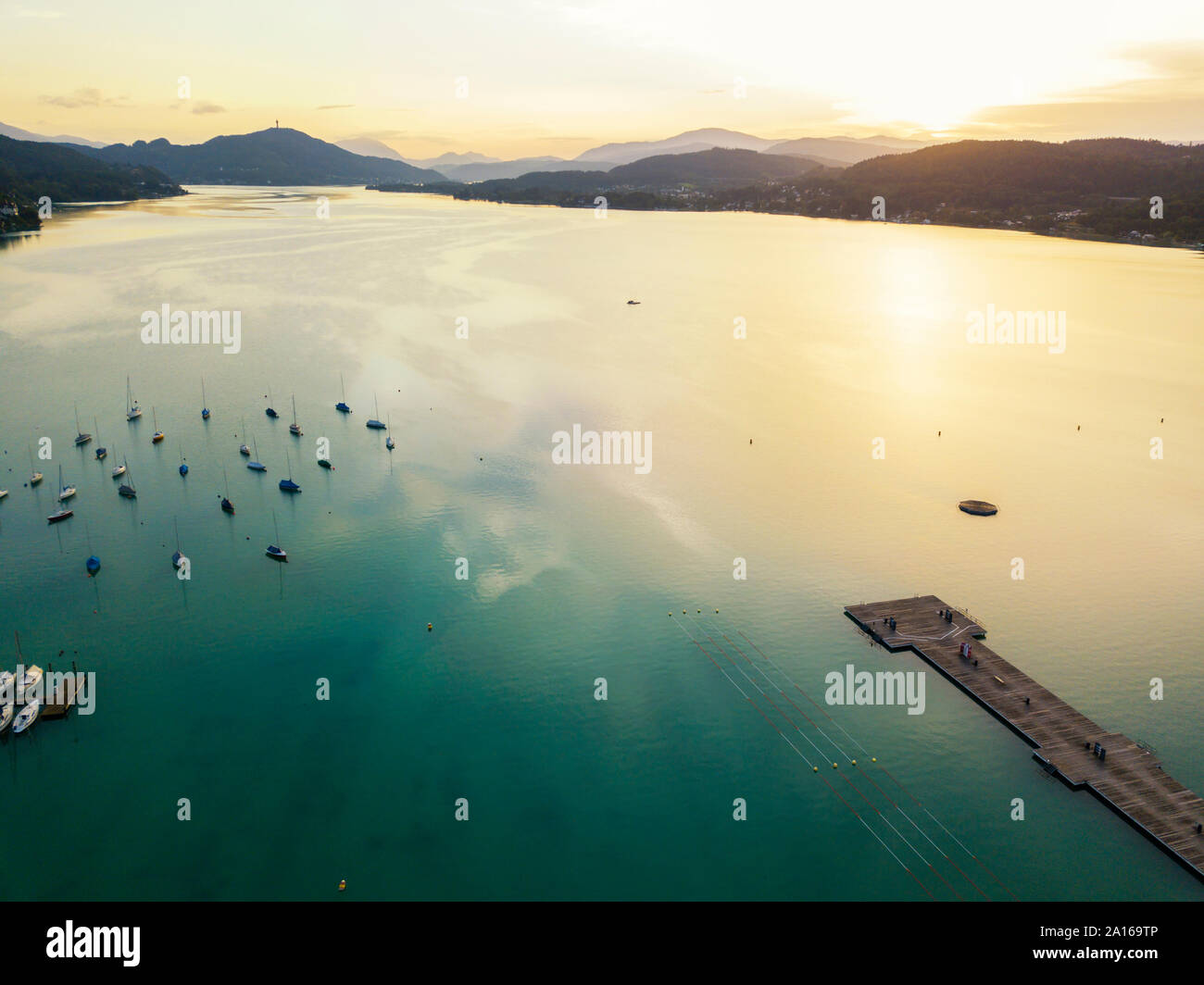 Luftaufnahme von Steg und Boote in Woerthersee gegen Himmel bei Sonnenuntergang Stockfoto