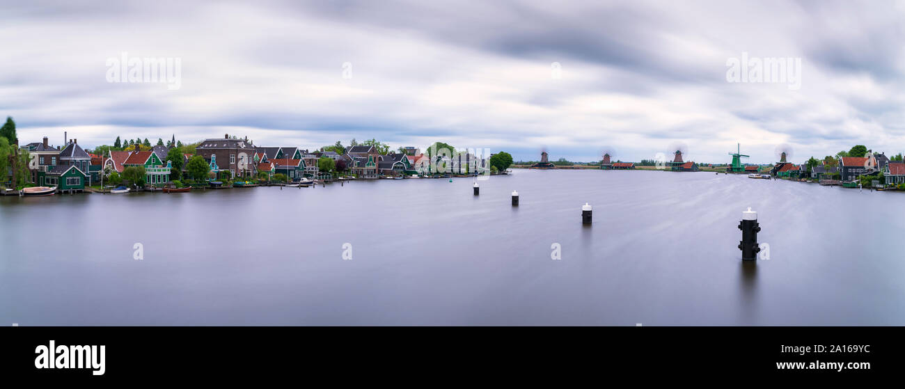 Panorama-aufnahme der Fluss Zaan gegen bewölkter Himmel, Zaanse Schans, Zaandam, Niederlande Stockfoto